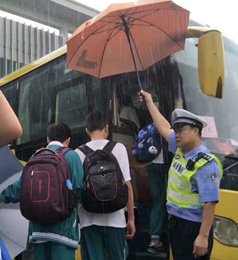 高考雨滂沱，佛山警察全身淋湿，为考生撑伞避雨