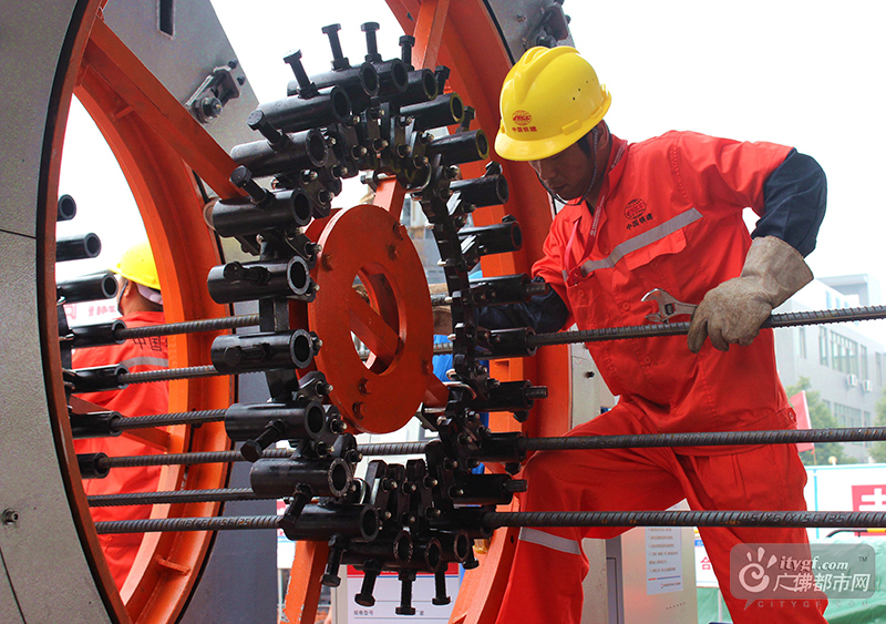 施工人员在操作数控钢筋笼滚焊机生产钢筋笼（摄影记者：广佛都市网记者李仁生）